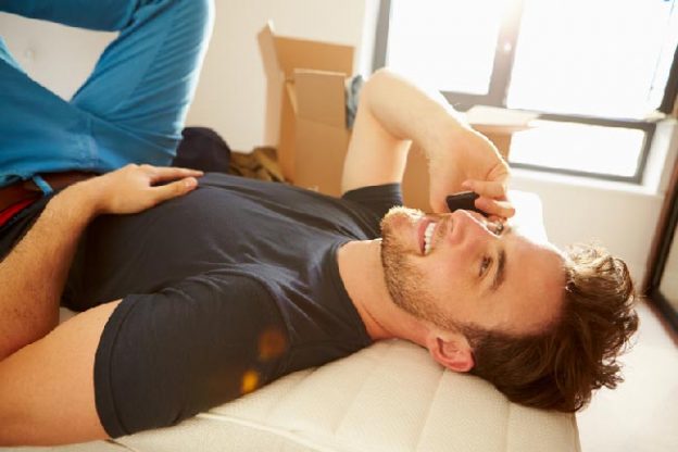 Attractive male lying down while talking into his mobile phone