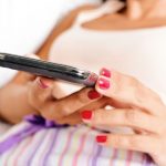 Woman with smart phone in bed