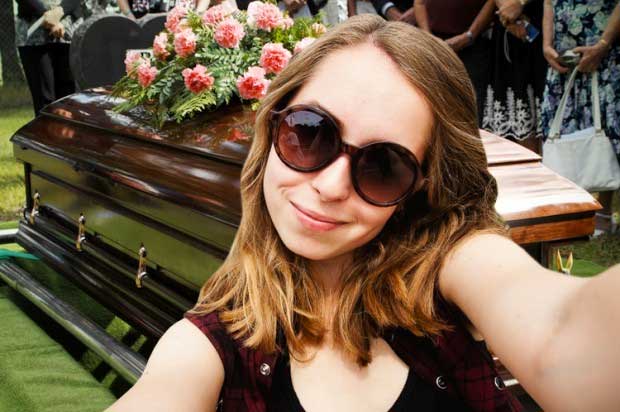 Female snapping selfie during funeral proceedings